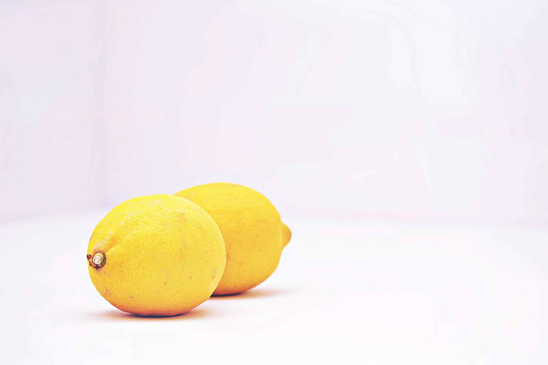 Two vibrant lemons on a white background, symbolizing freshness and renewed sensation